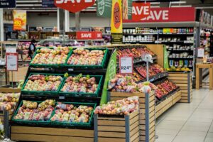 Detailhandelaar in winkel met kassasysteem en webshop op tablet