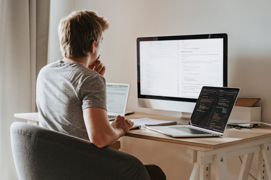 Freelance IT-consultant aan laptop met code en cloud-dashboard